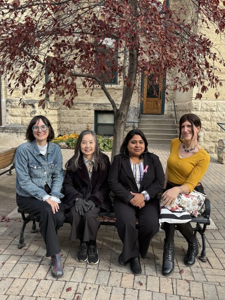 This is a photo of four of the members of BUFA's equity committee seated on a bench outside Clark Hall.